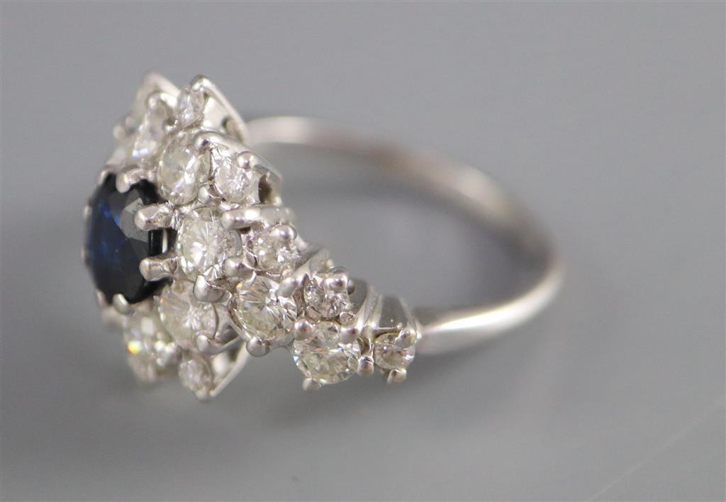 A modern 18ct white gold, sapphire and diamond cluster dress ring, with diamond set shoulders,